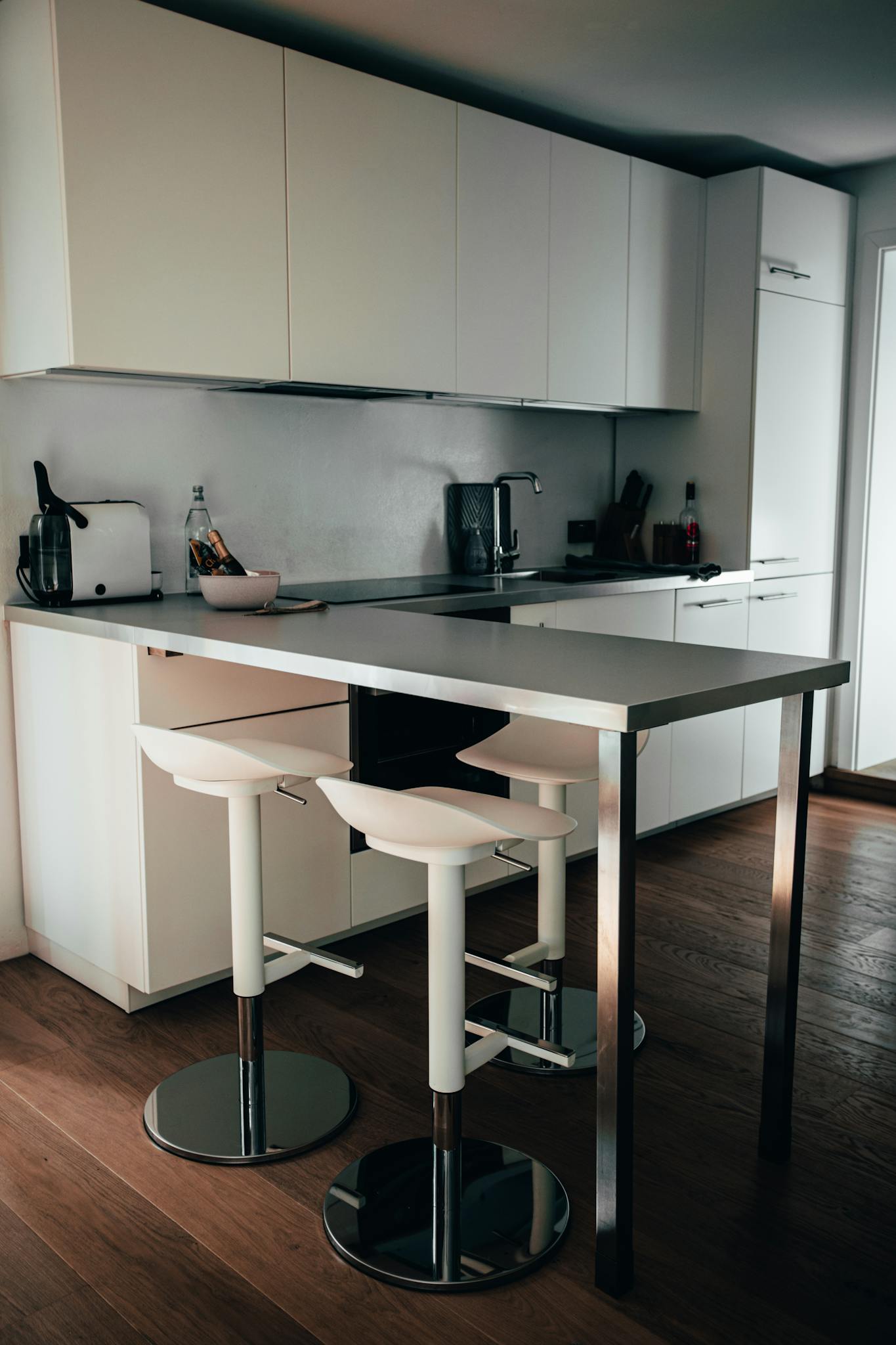 Contemporary minimalist kitchen with sleek counter and stools in Germany.